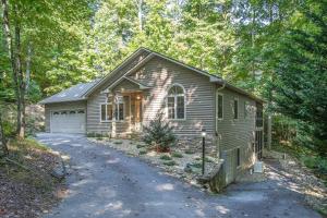 a small house in the woods with a driveway at Hummingbird Hideaway · Hummingbird Hideaway in Connestee Falls in Brevard