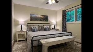 a bedroom with a bed with two tables and a window at Shady Creek Cabin · Shady Creek Cabin in Connestee Falls with s in Brevard +12 photos