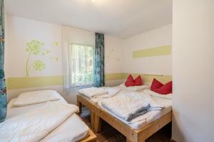 a room with three beds and a window at Bugalow 16 - Finnhütte in Niesky