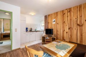 a living room with a table and a kitchen at Bugalow 16 - Finnhütte in Niesky