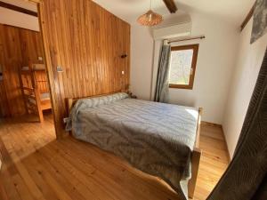 a bedroom with a bed and a wooden floor at Gîte le Suquet - en pleine nature in Dourbies