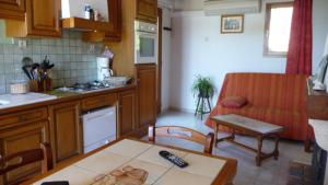 a kitchen and living room with a couch and a table at Gîte le Suquet - en pleine nature in Dourbies