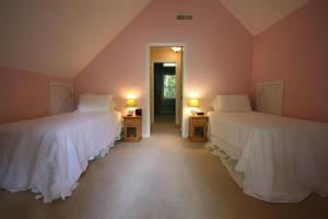two beds in a room with two lamps on tables at White Squirrel`s Nest · White Squirrel`s Nest in Sherwood Forest in Rosman