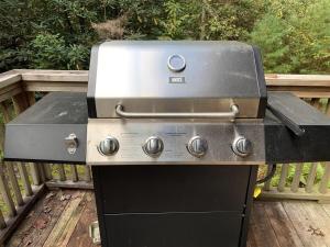 a grill sitting on a table on a deck at White Squirrel`s Nest · White Squirrel`s Nest in Sherwood Forest in Rosman +8 photos