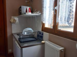 a kitchen with a dish drying rack on a refrigerator at Les Chambres Des Chtis in Abbeville