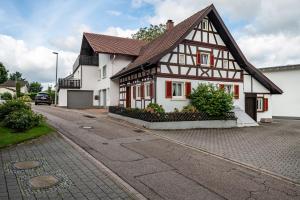 a white house with a brown roof on a street at Ferienhaus Albert in Bühl