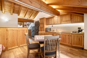 a kitchen with wooden cabinets and a table and chairs at Aux Pieds du Malatra' 1 in Saint-Rhémy-en-bosses