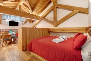 a bedroom with a red bed with two towels at Aux Pieds du Malatra' 1 in Saint-Rhémy-en-bosses