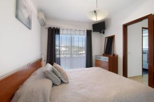 a bedroom with a large bed and a window at Villa Neves in Albufeira +19 photos
