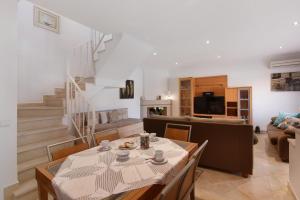 a living room with a table and chairs and a staircase at Villa Neves in Albufeira