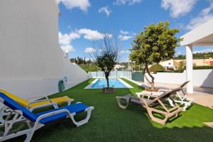 a backyard with lawn chairs and a swimming pool at Villa Neves in Albufeira