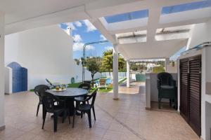 a patio with a table and chairs on it at Villa Neves in Albufeira