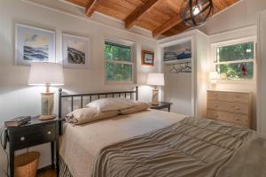 a bedroom with a large bed and two windows at The Deep Forest Green Cottage · The Deep Forest Green Cottage in Cedar Mountain