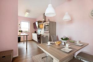 a kitchen and dining room with a wooden table in a room at Haus Eiderblick in Horst