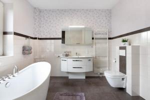 a bathroom with a tub and a sink and a toilet at Haus Eiderblick in Horst +25 photos