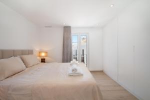 a white bedroom with a large bed and a window at Townhouse El Naranjal in Marbella +28 photos