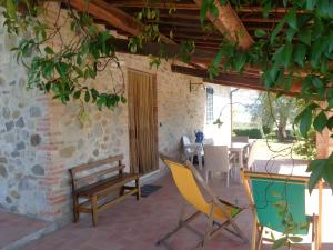 a patio with a bench and a table and chairs at La Valle Del Sole - Val D'Orcia in Castiglione dʼOrcia