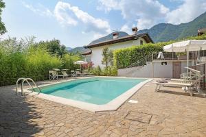 a swimming pool in front of a house at Eco Del Garda Bnb in Tenno
