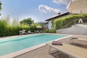 a swimming pool in front of a house at Eco Del Garda Bnb in Tenno