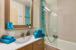 a bathroom with a sink and a shower with blue towels at Le Murmure pieds dans l'eau in La Grande Motte +108 photos