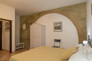 a bedroom with a bed and a brick wall at Podere Nuti - 2 Beloro in Cecina