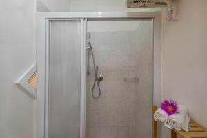 a shower with a glass door with a purple flower at Podere Nuti - 2 Beloro in Cecina +20 photos