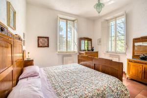 a bedroom with a bed and a dresser and windows at Palazzetto Bovini in Perugia +37 photos