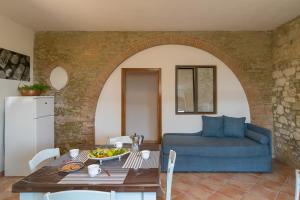 a living room with a table and a blue couch at Podere Nuti - 2 Beloro in Cecina