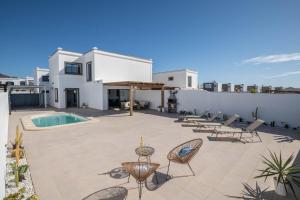 a patio with chairs and a swimming pool at Villa Esmeralda in Lanzarote