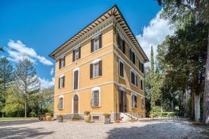 a large yellow building with a roof at Palazzetto Bovini in Perugia