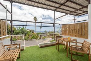 a patio with a table and chairs on the grass at La Atalaya in Adeje
