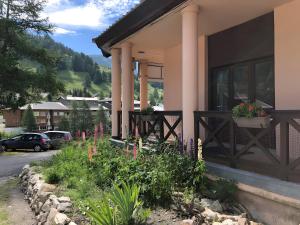 a house with a flower garden in front of it at La Baïta De La Foux in La Foux d'Allos
