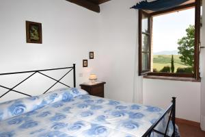 a bedroom with a bed and a window at La Valle Del Sole - Val D'Orcia in Castiglione dʼOrcia +37 photos