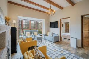 a living room with a couch and chairs and a tv at Finca El Aguilojo in Mombeltrán