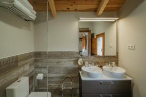a bathroom with two sinks and a mirror at Finca El Aguilojo in Mombeltrán +25 photos