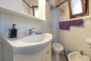 a white bathroom with a sink and a toilet at Casa San Fruttuoso in Carloforte +12 photos