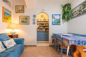 a living room with a blue couch and a table at Casa San Fruttuoso in Carloforte