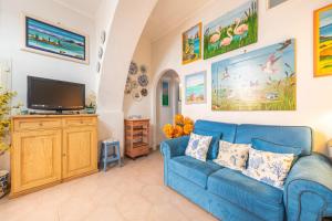 a living room with a blue couch and a tv at Casa San Fruttuoso in Carloforte