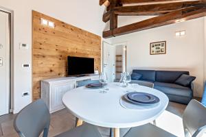 a dining room with a white table and chairs at Al segnavento Montese in Toscolano Maderno
