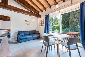 a living room with a table and chairs and a couch at Al segnavento Montese in Toscolano Maderno
