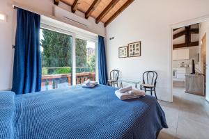 a bedroom with a blue bed and a large window at Al segnavento Montese in Toscolano Maderno +34 photos