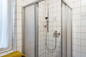 a shower in a bathroom with white tiles at Krüseliner Mühle - Bungalows in Krüselin +67 photos