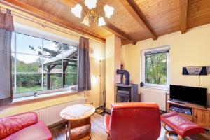 a living room with a couch and a tv at Krüseliner Mühle - Bungalows in Krüselin