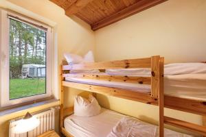 two bunk beds in a room with a window at Krüseliner Mühle - Bungalows in Krüselin