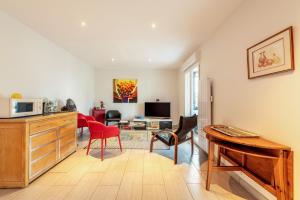 a living room with a desk and some chairs at Maison 4 pers à 5kms de la plage in Plouider