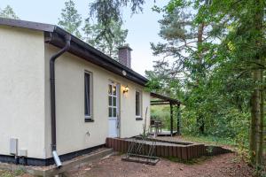a small white house with a porch at Krüseliner Mühle - Bungalows in Krüselin
