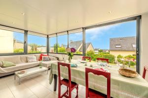 a dining room with a table and chairs and a large window at Maison 4 pers à 5kms de la plage in Plouider