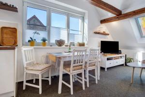 a dining room with a table and chairs and windows at gemütliche Ferienwohnung in Seenähe in Neustrelitz