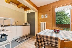 a kitchen and dining room with a table and a window at Agritur El Casel in Brentonico