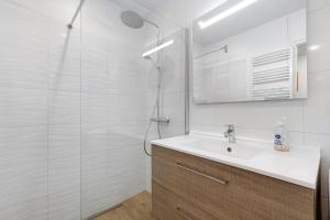 a white bathroom with a sink and a shower at Ile de Noirmoutier - Maison T4 in La Guérinière +22 photos